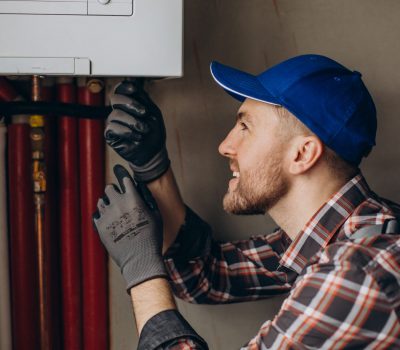 Service man adjusting house heating system Service man adjusting house heating system